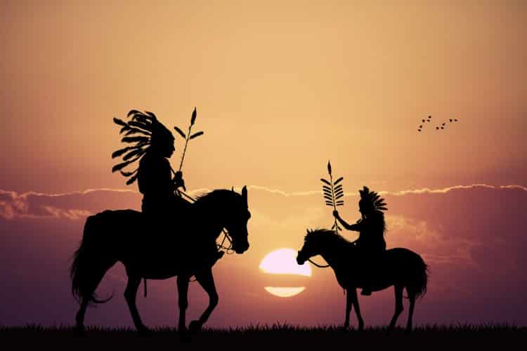 日落时分骑在马上的印第安人剪影